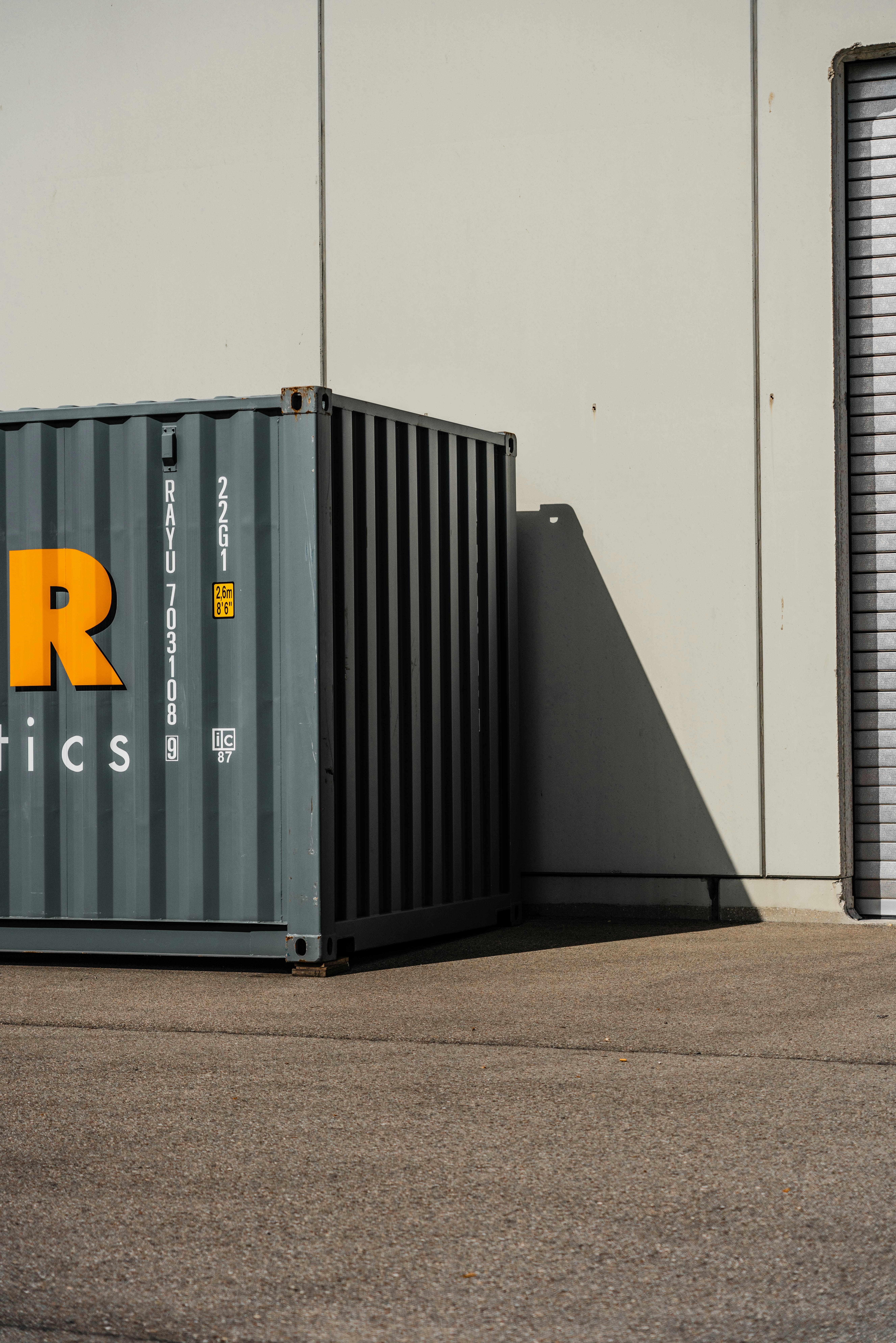 Grauer Container vor grauer Wand